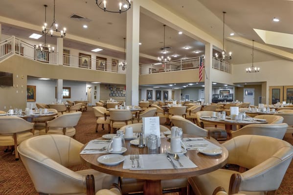 Spacious dining area with round tables and place settings
