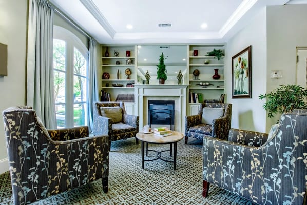 Lounge area with four armchairs and a coffee table by a fireplace