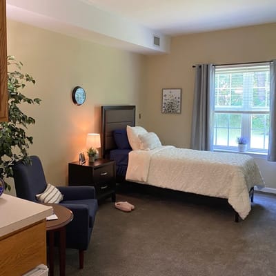 Cozy resident room with a bed and armchair