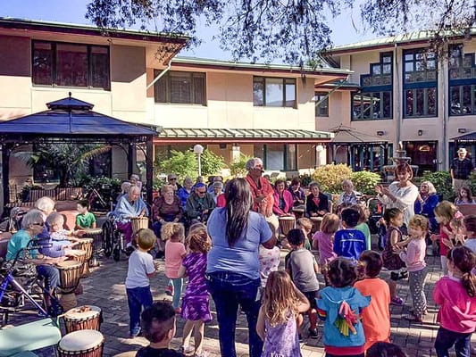Residents and children enjoying a music activity in the courtyard