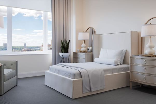 Bright bedroom with a bed, side tables, and large window