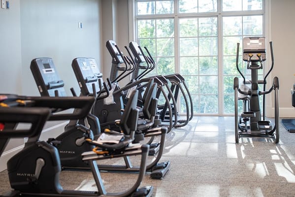 Fitness equipment lined up in a bright exercise room