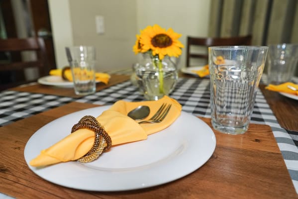 Dining table set with yellow napkin and sunflower