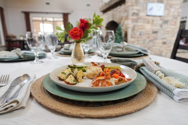 A beautifully arranged meal with vegetables and dessert on a dining table