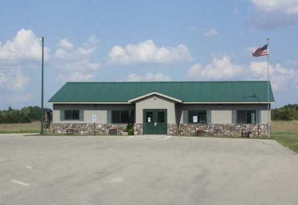 Exterior view of a single-story building with a green roof