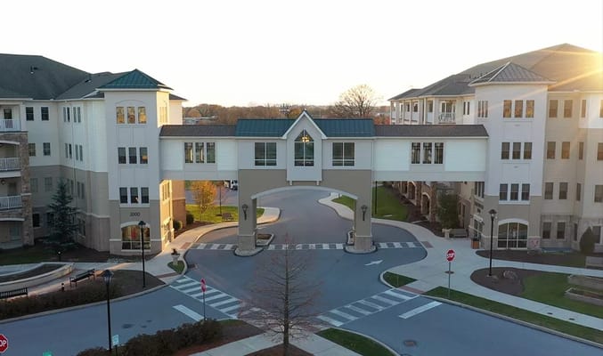 Exterior view of a senior living facility with a bridge