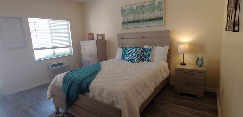 A well-decorated bedroom featuring a bed, nightstand, and dresser