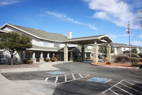 Exterior view of a senior living facility with a covered entrance