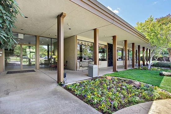 Exterior view of assisted living facility entrance with landscaping