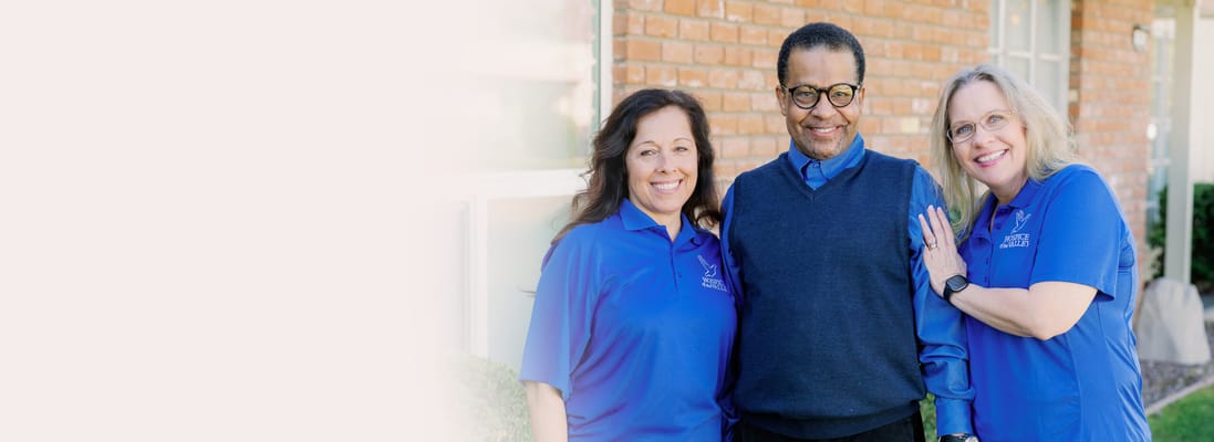 Staff and resident smiling together outdoors