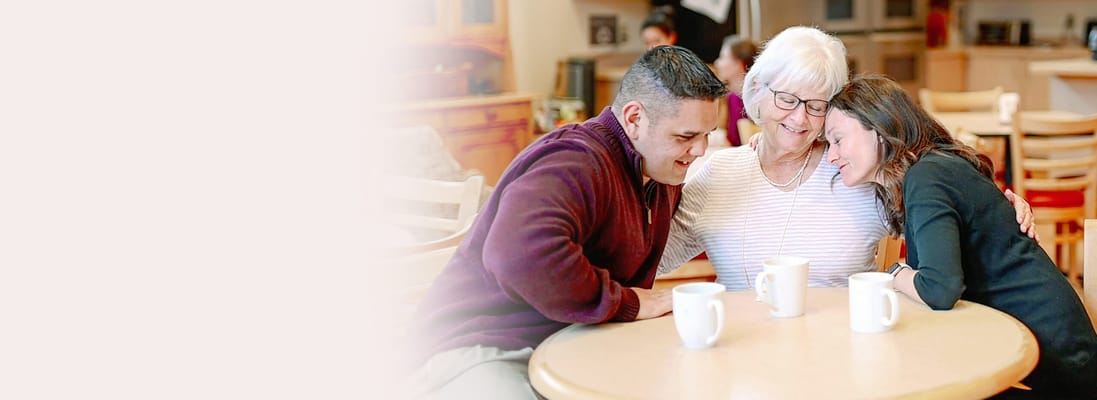 Residents and staff enjoying a moment together at a table
