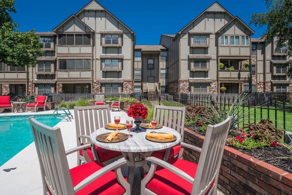 Outdoor dining setup by the pool at the facility