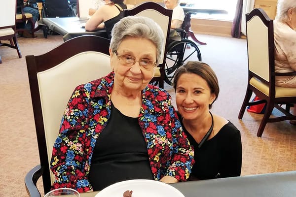 A resident and staff member sharing a moment in a common area
