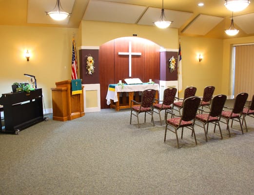Interior view of a multi-purpose room with chairs and cross