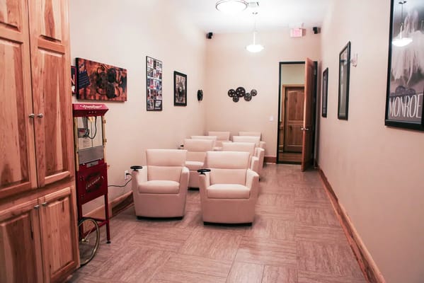 Interior waiting area with beige chairs and photos on the walls
