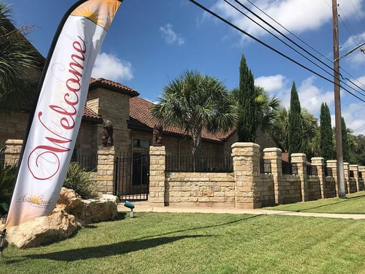 Stone building exterior with a welcome sign