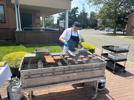Staff member grilling food outdoors
