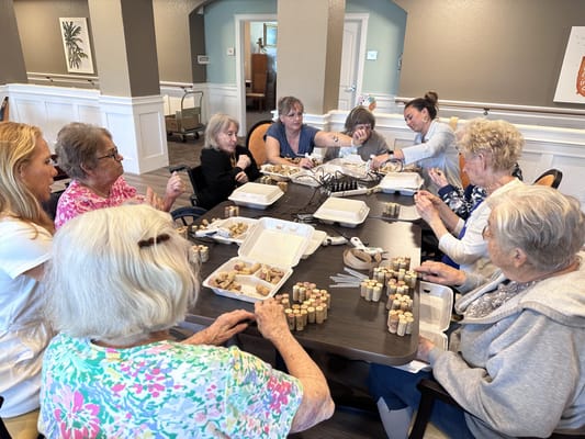 Residents participating in a crafting activity at a dining table