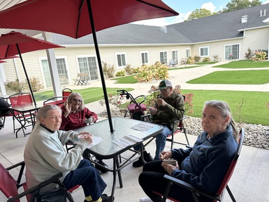 Residents enjoying time outdoors at a patio table