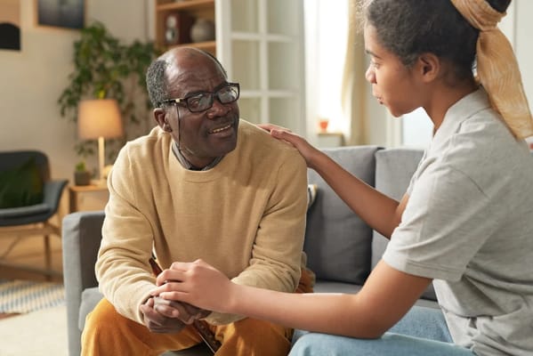 A resident and staff member interacting in a cozy living room