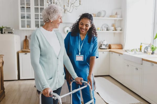Staff assisting a resident in a sunny kitchen
