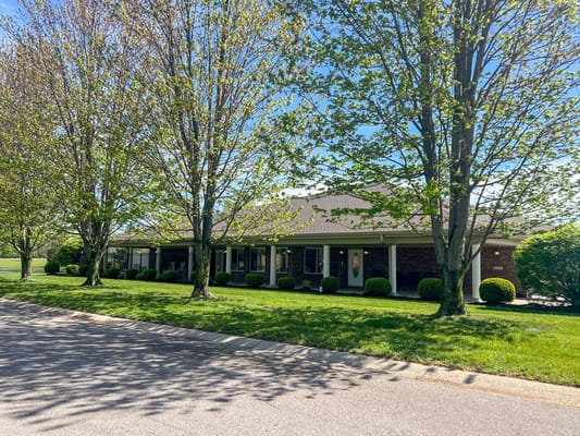 Exterior view of Heritage Assisted Living facility surrounded by trees.