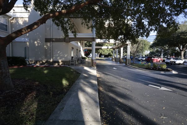 A view of the entrance with a covered drop-off area at Discovery Commons San Pablo.
