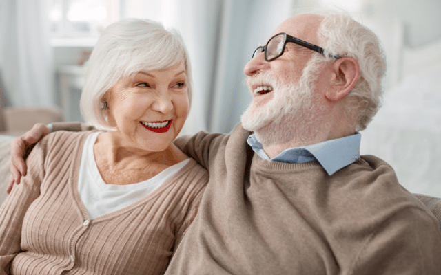 Two smiling seniors enjoying time together in a cozy setting