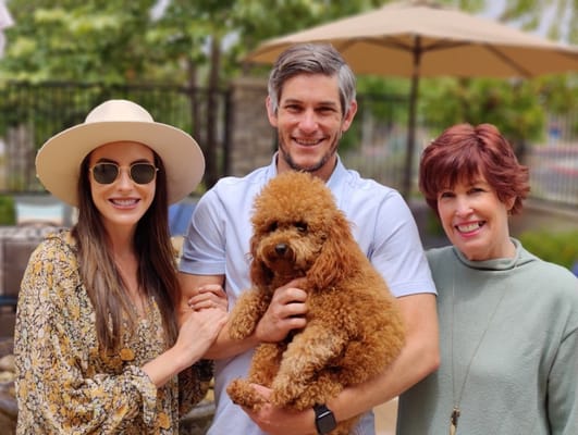 Residents and staff enjoying time outdoors with a dog