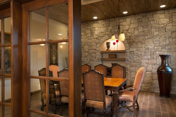 Stylish interior dining area with stone wall and wood accents