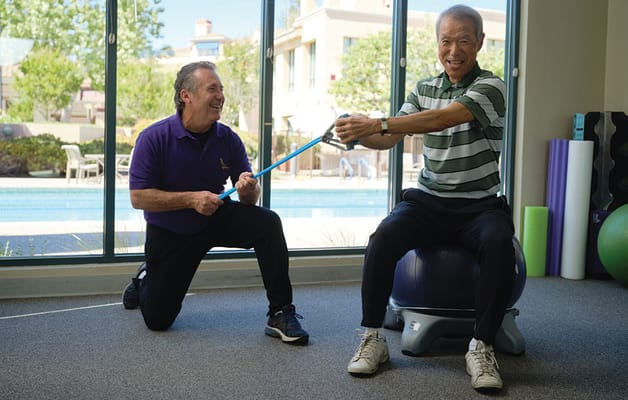 A resident participating in a physical activity with staff assistance