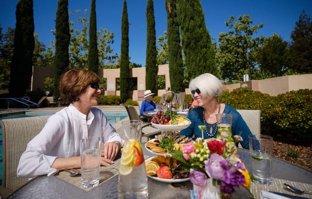 Two residents enjoying a meal outdoors at a table