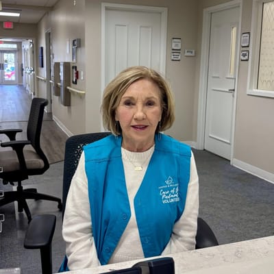 A volunteer at the reception desk in a senior care facility