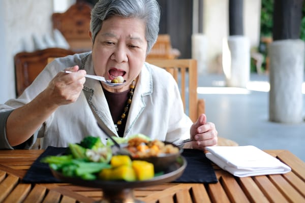 Resident enjoying a meal in a dining area