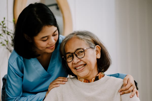 Caregiver smiling with a resident in a bright room