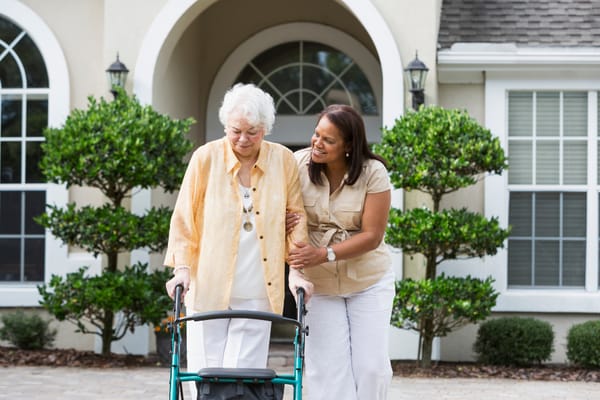 A staff member assisting a resident outdoors.