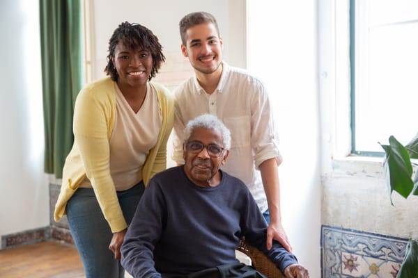 A senior man posing for a photo with two younger companions