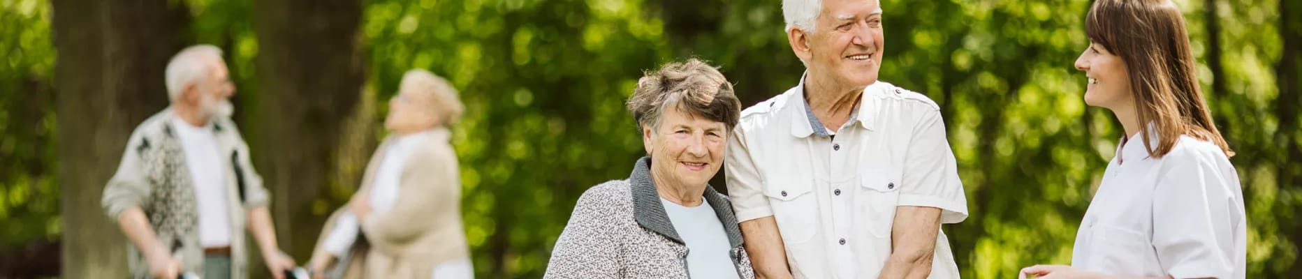 Residents and staff interacting in a green outdoor space