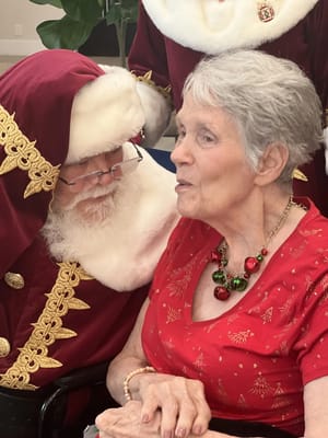 Senior resident enjoying a visit with Santa Claus