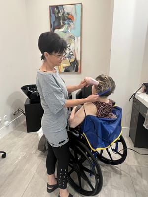 Staff providing hair styling service to a resident