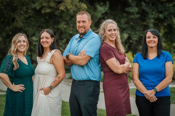 Staff members standing outdoors in a friendly pose