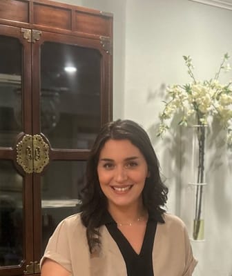 Staff member smiling in a cozy interior setting