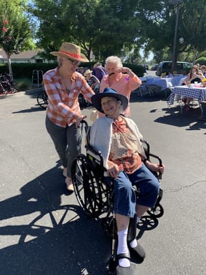 Residents enjoying an outdoor event with staff assistance