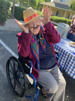 Resident in a wheelchair wearing a sombrero and mustache