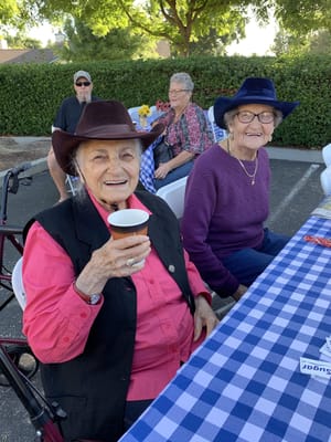 Residents enjoying an outdoor event with cowboy hats