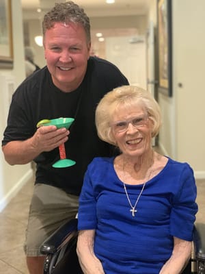 Resident smiling with a visitor in an indoor setting