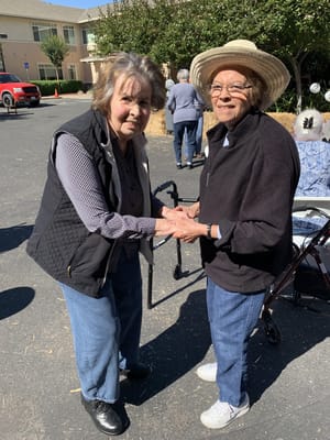 Two residents interacting outdoors at the facility