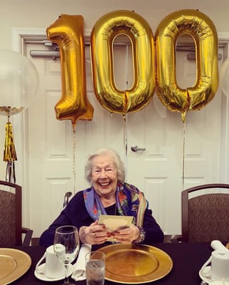 Resident celebrating their 100th birthday with balloons