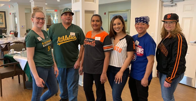 Staff and residents in team jerseys at a community event