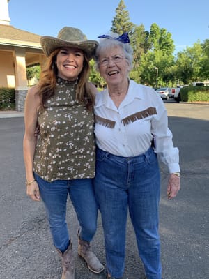 Two women smiling outside at a facility event